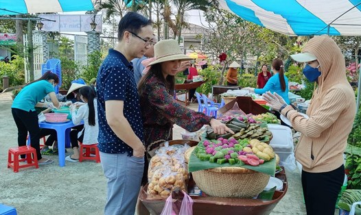 Du khách thích thú lựa chọn các món bánh mình ưa thích khi đến tham quan Làng hoa Sa Đéc. Ảnh: Thanh Nghĩa