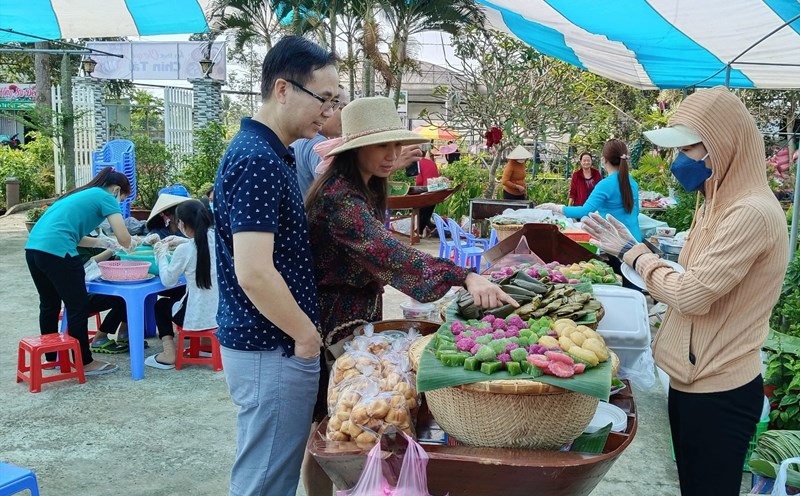 Du khách thích thú lựa chọn các món bánh mình ưa thích khi đến tham quan Làng hoa Sa Đéc. Ảnh: Thanh Nghĩa