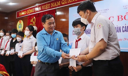Chủ tịch LĐLĐ tỉnh Quảng Nam Phan Xuân Quang tặng quà hỗ trợ con đoàn viên có thành tích xuất sắc trong học tập. 
Ảnh: Phương Nguyên