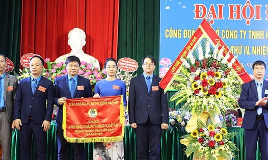 Lãnh đạo Liên đoàn Lao động tỉnh Hà Nam tặng Cờ đơn vị có thành tích xuất sắc trong phong trào thi đua năm 2022 cho Công đoàn cơ sở Công ty TNHH Hệ thống dây dẫn Sumi Việt Nam. Ảnh: Thuý Chinh
