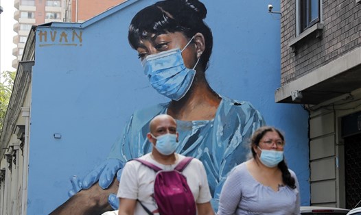 Người dân đeo khẩu trang nhằm ngăn chặn lây lan COVID-19 trên đường phố Santiago, Chile. Ảnh: AFP
