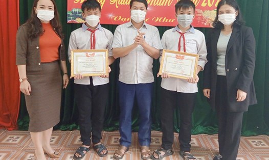 Ban Giám hiệu Trường THCS Yên Hòa trao giấy khen cho 2 học sinh nhặt được của rơi tìm người trả lại. Ảnh: TT.