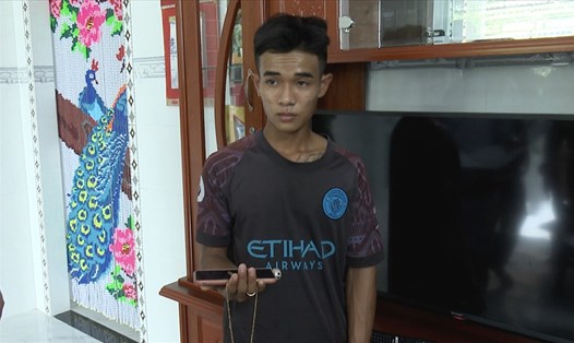 Đối tượng Thái Hồng Dương đang cầm điện thoại và dây chuyền vàng cướp được của nạn nhân sau khi hiếp dâm rồi đem về nhà cất giấu. Ảnh: PV