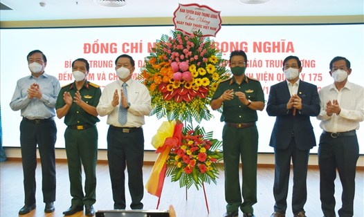 Trưởng Ban Tuyên giáo Trung ương Nguyễn Trọng Nghĩa tặng hoa chúc mừng đội ngũ y bác sĩ, nhân viên y tế tại Bệnh viện Quân y 175. Ảnh: SH