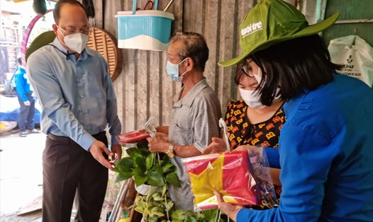 Ông Nguyễn Hồ Hải (bìa trái) - Phó Bí thư Thành ủy TPHCM tặng cờ Tổ quốc và cây xanh cho người dân phường 15, quận Tân Bình. Ảnh: Nam Dương