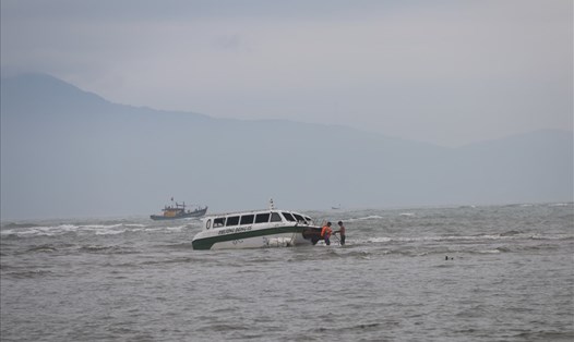 Người dân đang trục vớt cano bị chìm ở biển Cửa Đại. Ảnh: Thanh Chung