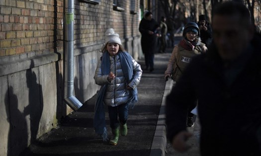 Cô bé Kira Shapovalova người Ukraina đang cùng người thân chạy tới hầm trú ẩn để tránh bom vào sáng 26.2. Ảnh: AFP
