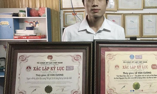 Thầy giáo Lê Văn Cường bên 2 tác phẩm được xác lập kỉ lục Guinness của mình. Ảnh: NVCC.
