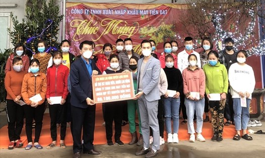 Chủ tịch Liên đoàn Lao động huyện Lạng Giang Hà Văn Kha (hàng đầu, bên trái) tặng quà Tết cho công nhân lao động tại Công ty TNHH XNK may Tiến Đạt. Ảnh: LĐLĐ huyện Lạng Giang