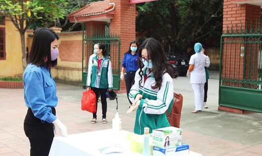 Các trường học trên địa bàn tỉnh Ninh Bình bố trí cán bộ, giao viên tổ chức đưa đón học sinh ngay tại cổng trường và thực hiện việc đo thân nhiệt, sát khuẩn theo quy định. Ảnh: NT