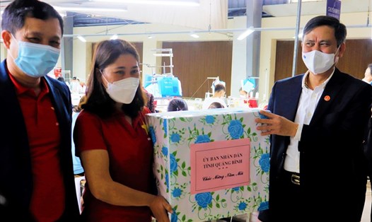 Chủ tịch UBND tỉnh Quảng Bình Trần Thắng (bên phải) trao quà cho công nhân lao động tại Xí nghiệp May Hà Quảng. Ảnh: H.L