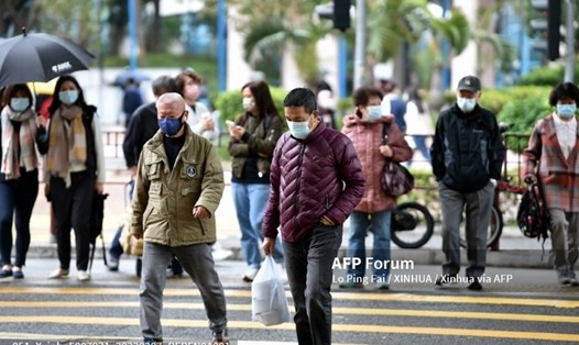 Mọi người đeo khẩu trang đi bộ trên một con phố ở Hong Kong. Ảnh: AFP