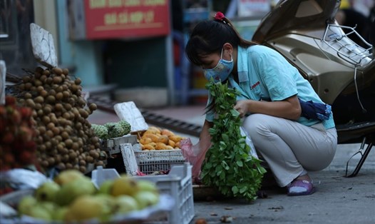 Nữ công nhân Khu công nghiệp Thăng Long (Đông Anh, Hà Nội) đi chợ sau khi tan ca. Ảnh: Hải Nguyễn