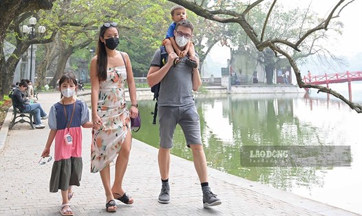 Anh Marchin (Ba Lan) cùng gia đình vui vẻ đi bộ tại Hồ Gươm ngày đầu tiên du lịch Việt Nam chính thức mở cửa hoàn toàn.