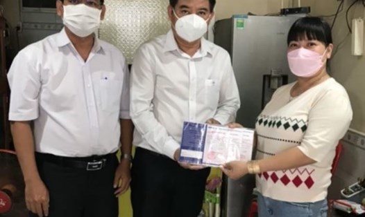 Đại diện Công đoàn Điện lực Việt Nam trao sổ tiết kiệm cho vợ anh Lân. Ảnh: CĐCC