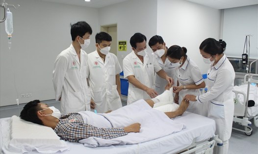 TS Nguyễn Viết Ngọc thăm khám cho bệnh nhân sau khi phẫu thuật. Ảnh: BVCC