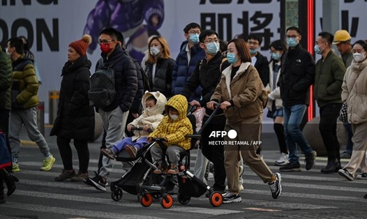 Một cặp vợ chồng cùng các con trên phố đi bộ ở Thượng Hải, Trung Quốc. Ảnh minh họa. Ảnh: AFP