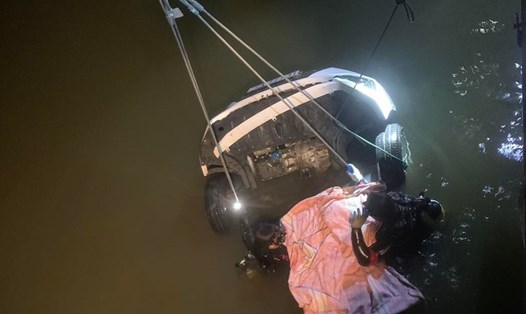 Chiếc ôtô và thi thể nạn nhân được lực lượng cứu hộ đưa lên khỏi sông. Ảnh: CA cung cấp.