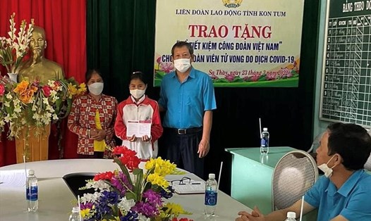 Ông Lê Ích Dàng - Phó Chủ tịch LĐLĐ tỉnh Kon Tum trao sổ tiết kiệm cho cháu Y Cam. Ảnh NA