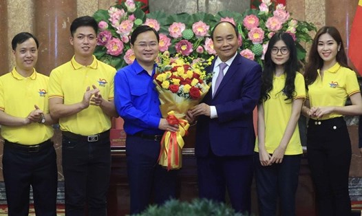 Chủ tịch nước Nguyễn Xuân Phúc tặng hoa chúc mừng đoàn viên, thanh niên nhân kỷ niệm 91 năm Ngày thành lập Đoàn. Ảnh: TTXVN
