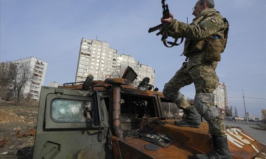 Binh sĩ Ukraina trên xe bọc thép của Nga bị phá hủy ở Kharkiv. Ảnh: AP