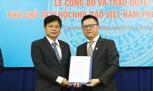 Chủ tịch Hội Nhà báo Việt Nam Lê Quốc Minh trao quyết định cho ông Trần Trọng Dũng (bìa trái).   Ảnh: M.Q
