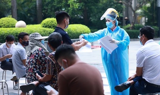 Nhân viên y tế hỗ trợ người dân lấy mẫu test nhanh COVID-19. Ảnh: Hải Nguyễn