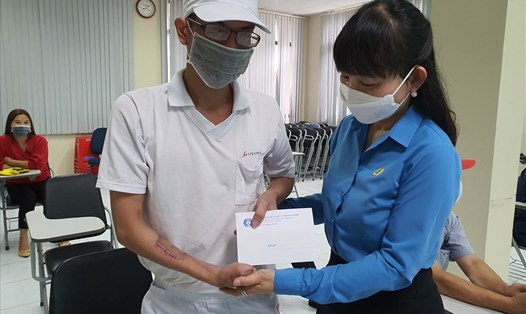 Bà Đặng Thị Kim Chi - Chủ tịch Công đoàn KCN VSIP (Bình Dương) - trao hỗ trợ cho một công nhân bị tai nạn lao động. Ảnh: Đ.T