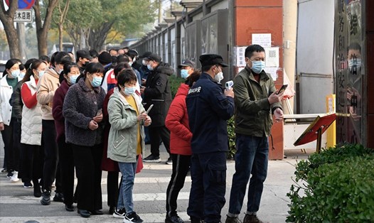 Người dân xếp hàng chờ đo nhiệt độ ở Bắc Kinh, Trung Quốc. Ảnh: AFP