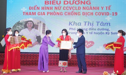 Chủ tịch UBMTTQ tỉnh Võ Thị Minh Sinh, Phó Chủ tịch UBND tỉnh Nghệ An Bùi Đình Long trao tặng Bằng khen cho nữ cán bộ y tế xuất sắc. Ảnh: QĐ