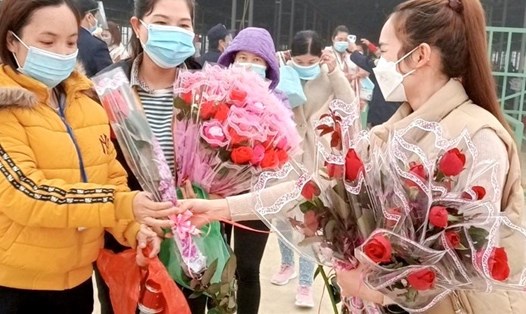 Cán bộ công đoàn Công ty TNHH Sản xuất Giày Chungjye Tuyên Quang đứng trước cổng nhà máy tặng hoa cho nữ công nhân. Ảnh: CĐCC