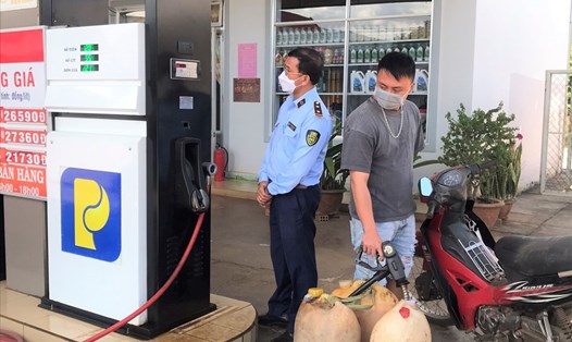 Lực lượng chức năng kiểm tra lập biên bản vi phạm hành chính đối với cửa hàng xăng dầu Trang Phước Lộc. Ảnh: Khánh Phúc