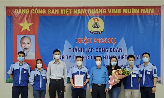 Chủ tịch Công đoàn Các khu công nghiệp - chế xuất Hà Nội Đinh Quốc Toản (thứ 4, từ phải sang) trao Quyết định thành lập Công đoàn cơ sở Công ty TNHH Cơ khí HTMP Việt Nam. Ảnh: CĐN