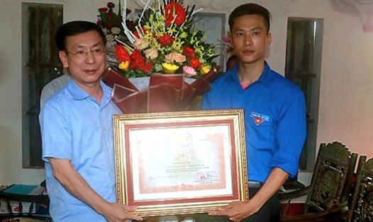 Chủ tịch UBND tỉnh Nam Định - Phạm Đình Nghị trao Bằng khen của Thủ tướng Chính phủ cho anh Nguyễn Đức Chính. Ảnh: CTV