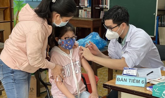 Phụ huynh cùng học sinh đi tiêm vaccine COVID-19 cho trẻ. Ảnh: Huyên Nguyễn