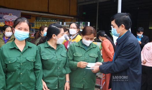 Ông Lường Minh Xuấn  - Phó Chủ tịch LĐLĐ tỉnh Sơn La trao phiếu mua hàng giảm giá cho người lao động. Ảnh: Khánh Linh