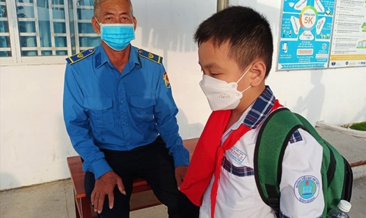 Ông Chín Hoàng với công việc bảo vệ tại một trường tiểu học ở quận Cái Răng, TP Cần Thơ. Ảnh: Q.T