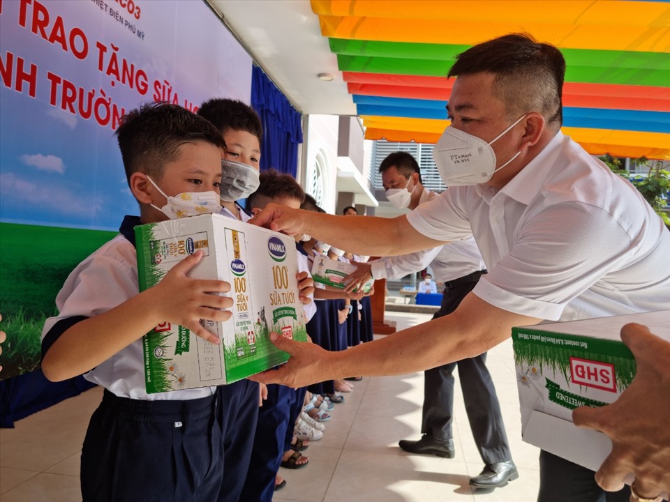 Ông Phan Bửu Đảo - Phó Chủ tịch Công đoàn Cơ quan EVNGENCO3 - trao tặng sữa học đường cho các học sinh Trường Tiểu học Lê Lợi. Ảnh: Nam Dương