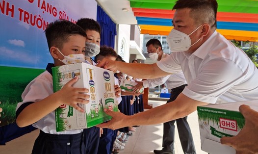 Ông Phan Bửu Đảo - Phó Chủ tịch Công đoàn Cơ quan EVNGENCO3 - trao tặng sữa học đường cho các học sinh Trường Tiểu học Lê Lợi. Ảnh: Nam Dương