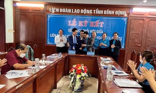 Chủ tịch LĐLĐ Nguyễn Mạnh Hùng (phải) và Giám đốc Sở Kế hoạch - Đầu tư Bình Định Nguyễn Thành Hải trao văn bản thỏa thuận kế hoạch phối hợp công tác