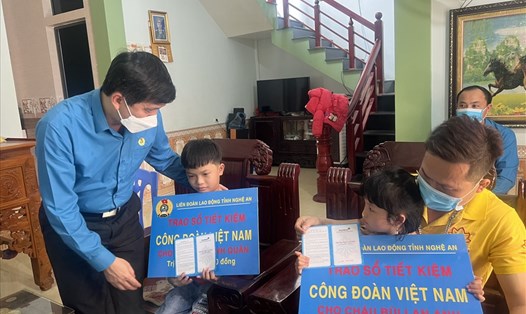 Chủ tịch LĐLĐ tỉnh Nghệ An Kha Văn Tám trao tặng “Sổ tiết kiệm Công đoàn Việt Nam” cho con nữ đoàn viên tử nạn vì dịch bệnh. Ảnh: TT