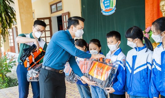 Đại diện Nhà tài trợ - Vietcombank, Quỹ xã hội từ thiện TLV Lao Động trao tặng cặp phao cho các học sinh Nghệ An. Ảnh: QC