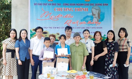 Đại diện Sở GDĐT và Công đoàn ngành Giáo dục tỉnh Quảng Bình nhận đỡ đầu cho 2 học sinh có hoàn cảnh khó khăn tại huyện Minh Hóa. Ảnh: H.L