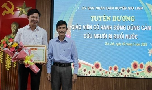 Lãnh đạo UBND huyện Gio Linh tuyên dương thầy giáo dũng cảm cứu người bị đuối nước. Ảnh: CTV.