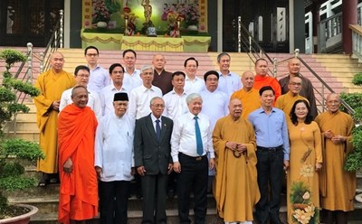 Ông Đỗ Văn Chiến và các thành viên trong đoàn công tác chụp ảnh lưu niệm cùng các chức sắc tại Văn phòng II, Trung ương GHPG Việt Nam. Ảnh: Phạm Đông