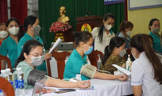Các nữ CNLĐ được kiểm tra huyết áp trong “Ngày hội vì sức khỏe Người lao động” do LĐLĐ TPHCM tổ chức sáng 15.5. Ảnh: Chân Phúc