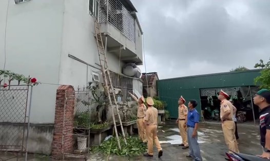 CSGT Công an huyện Thanh Miện sử dụng thang tre leo lên tầng 2 giải cứu 4 mẹ con chị Hiền bị mắc kẹt trong đám cháy. Ảnh: Công an tỉnh Hải Dương