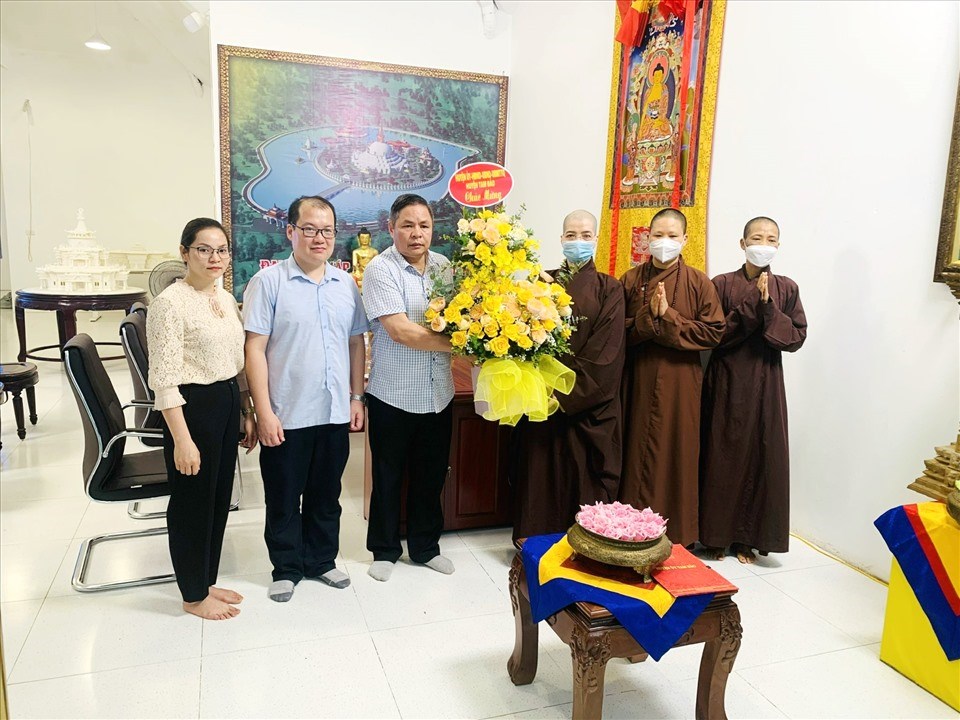Chư ni Đại Bảo tháp Tây Thiên đón nhận lẵng hoa tươi thắm chúc mừng Phật đản từ đại diện chính quyền huyện Tam Đảo. Ảnh: BTC