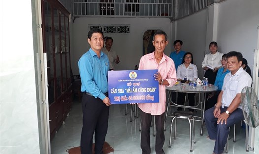 Ông Phạm Thế Minh đại diện Liên đoàn Lao động tỉnh trao hỗ trợ cho đoàn viên Trần Quốc Tân. Ảnh CĐGD