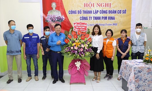 Ông Vũ Văn Nghĩa, Chủ tịch LĐLĐ tỉnh Nam Định (thứ 4 từ trái sang) tặng hoa chúc mừng Công đoàn Công ty TNHH Pim Vina. Ảnh: CĐNĐ